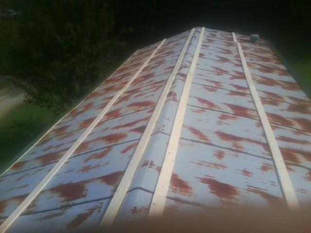Rusted metal roof panels with new wood purlins before replacement — Storm Damage Roof Repair in Pinebluff by Roofing Brothers