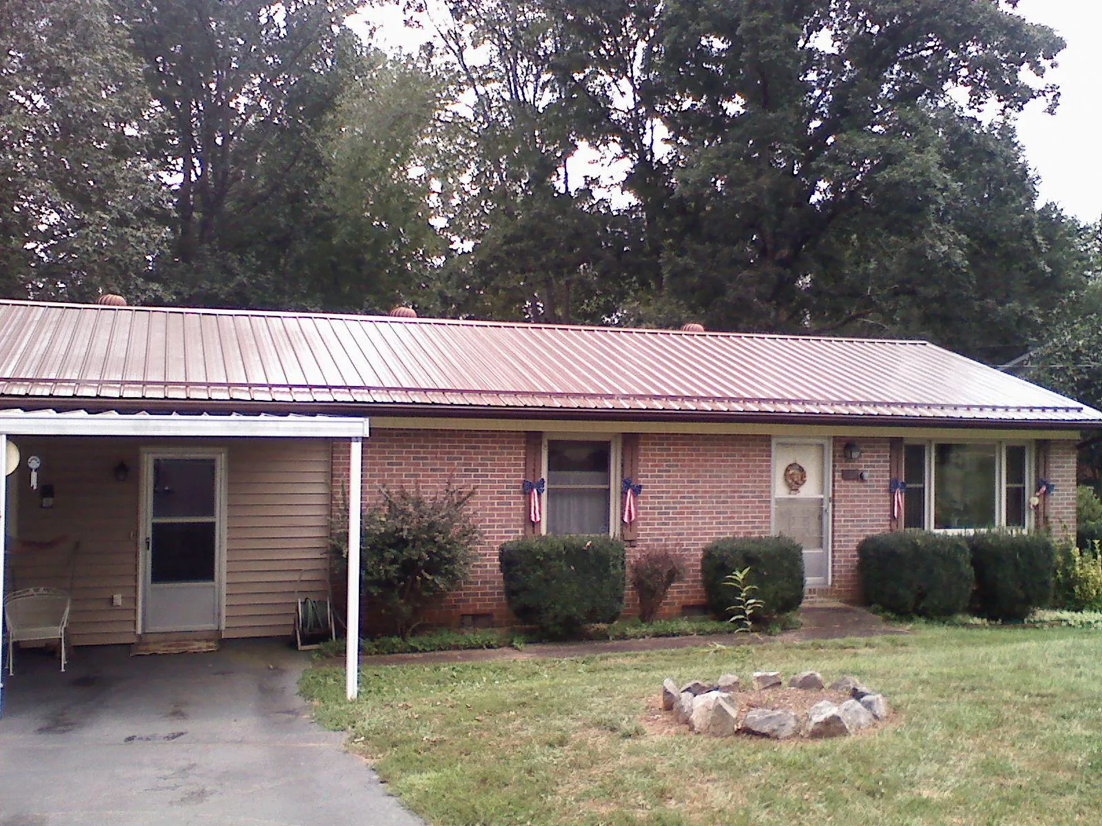 Bronze metal roof and carport on a brick ranch home — Roof Repair work by our crew in Pinebluff